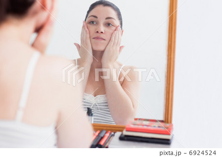 Woman applying cream on face Woman applying cream on face 6924524