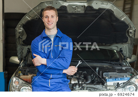 Mechanic leaning aganist car 6924674