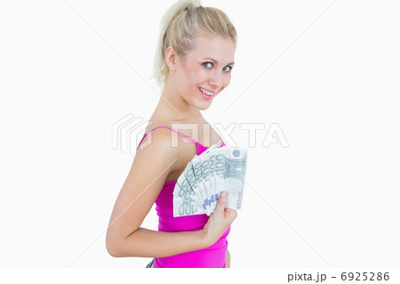 Portrait of happy young woman holding fanned euro banknotes Portrait of happy young woman holding fanned euro banknotes 6925286