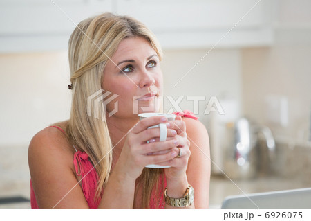 Close-up of young thoughtful woman with coffee cup 6926075