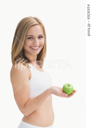 Portrait of happy young woman holding green apple 6926954