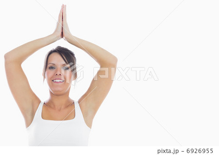 Portrait of smiling woman joining hands over head 6926955