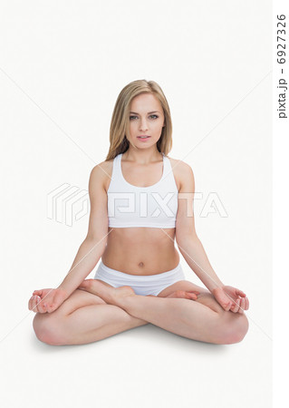 Portrait of young woman sitting in lotus position with eyes clos 6927326