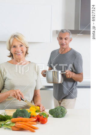Husband bringing a pan to his smiling wife 6927524