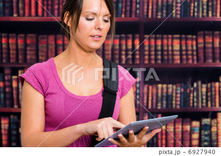 Girl touching a tablet in library 6927940