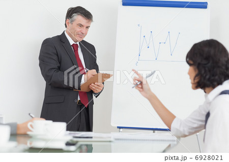 Businessman writing on clipboard in office 6928021
