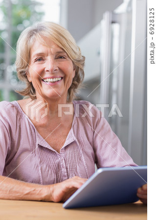 Happy mature woman using her digital tablet Happy mature woman using her digital tablet 6928125