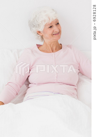Happy woman sitting in bed 6928128