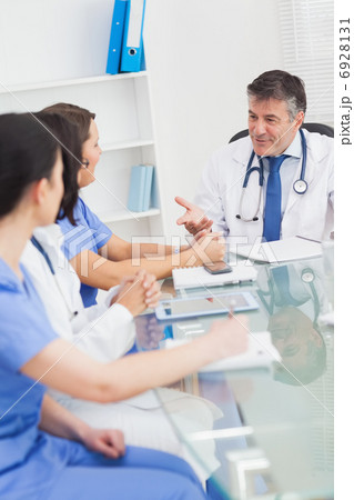 Meeting between a doctor and three nurses smiling 6928131