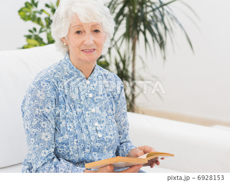 Elderly cheerful woman reading a old novel 6928153