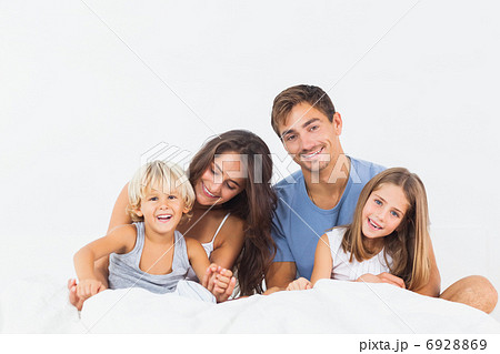 Happy family posing on the bed 6928869