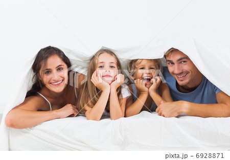 Family in the duvet smiling 6928871