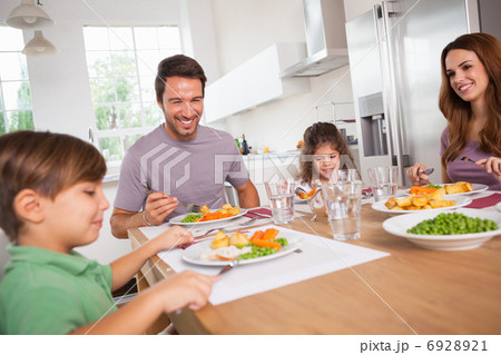 Family smiling around a good meal Family smiling around a good meal 6928921