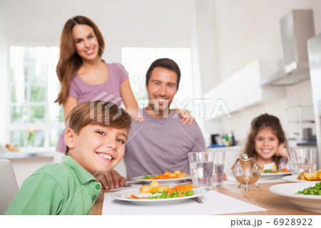 Family looking at the camera at dinner time Family looking at the camera at dinner time 6928922
