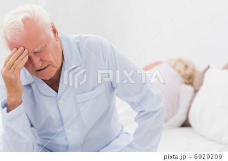 Old man suffering while woman sleeping 6929209