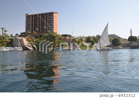 アスワンを流れるナイル川、ファルーカが浮かび、高級ホテルが立っている 6932312