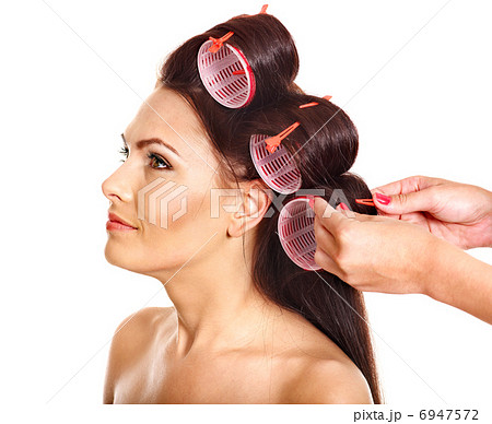 Woman wear hair curlers on head. 6947572