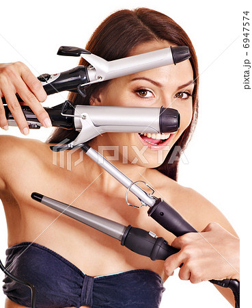 Woman holding iron curling hair. 6947574