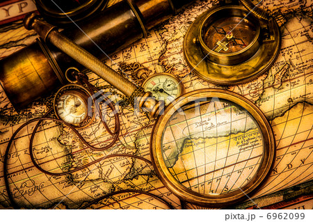 Vintage magnifying glass lies on an ancient world map 6962099