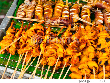 Traditional Thai food at market. Grilled seafood on sticks. Cala 6963548