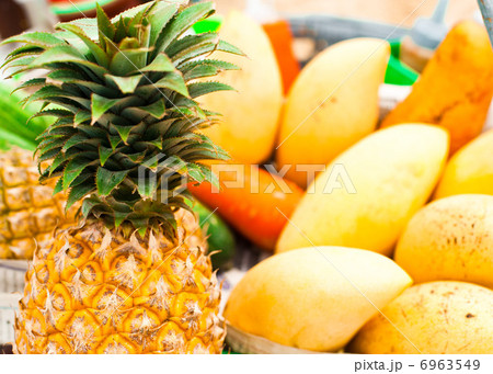 Selling tropical fruits and vegetables at market Selling tropical fruits and vegetables at market 6963549