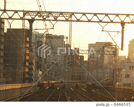 夕焼け色に染まる電車のレールと架線 6966535