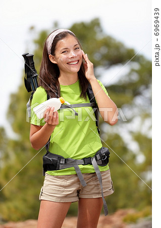Sunscreen woman hiking applying sun lotion 6969439