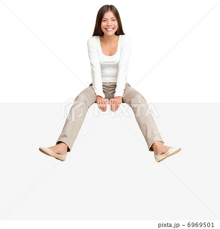 Woman sitting on billboard sign edge 6969501