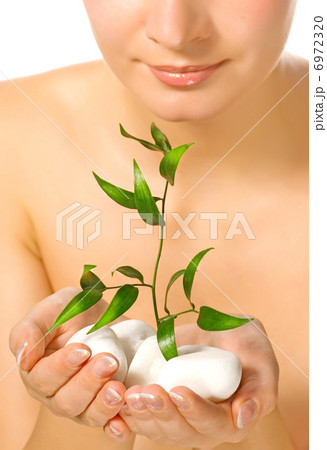 Beautiful blond girl holding young plant growing up through ston Beautiful blond girl holding young plant growing up through ston 6972320