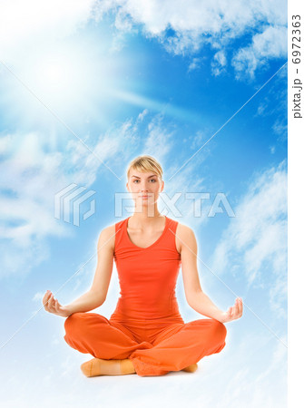 Beautiful young woman meditating in the sky 6972363