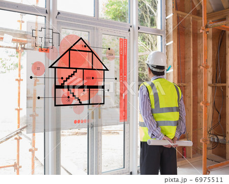 Architect holding a plan while looking outside 6975511