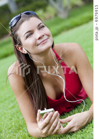 Beautiful Brunette Woman laying Down Listening to MP3 Player Beautiful Brunette Woman laying Down Listening to MP3 Player 6976915