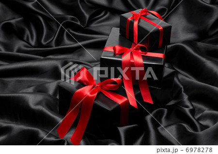 Black gift boxe with red satin ribbons and bows, over black satin Black gift boxe with red satin ribbons and bows, over black satin 6978278