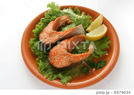 fried salmon on lettuce with lemon 6979034