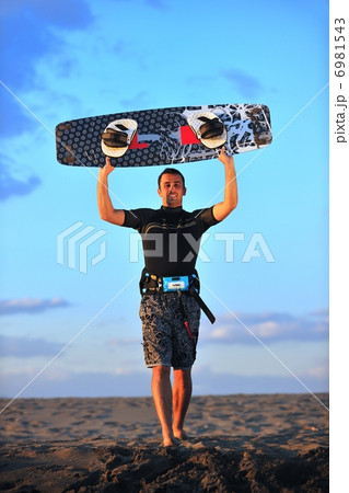 Portrait of a young kitsurf man at beach on sunset Portrait of a young kitsurf man at beach on sunset 6981543