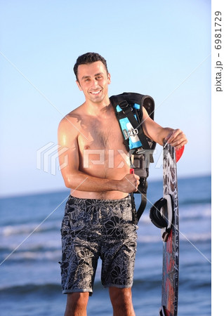Portrait of a young kitsurf man at beach on sunset Portrait of a young kitsurf man at beach on sunset 6981729
