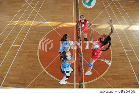 girls playing volleyball indoor game 6985459