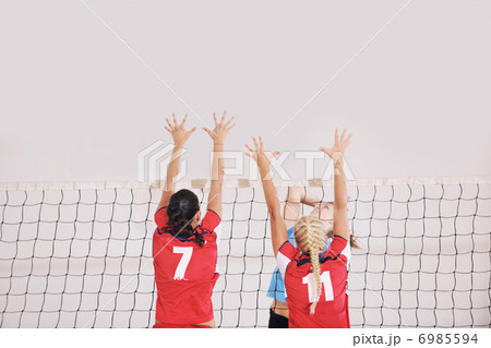 girls playing volleyball indoor game 6985594