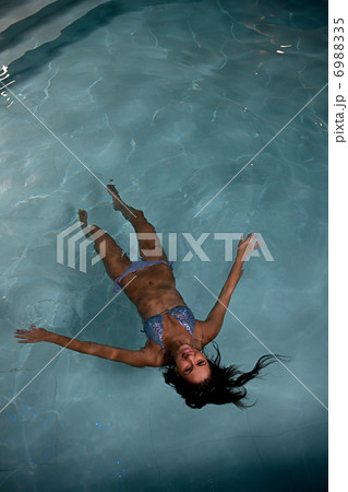 pretty young lady relaxing in the swimming pool 6988335