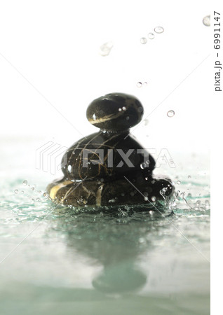 isolated wet zen stones with splashing water drops 6991147