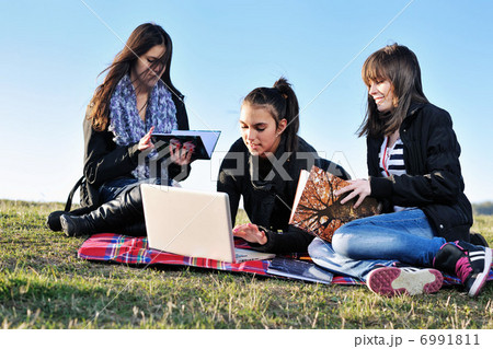 group of teens working on laptop outdoor 6991811