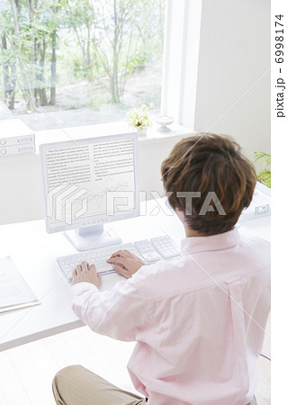 デスクワークをする男性の後ろ姿 6998174