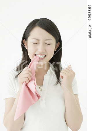ハンカチを噛む若い女性の写真素材
