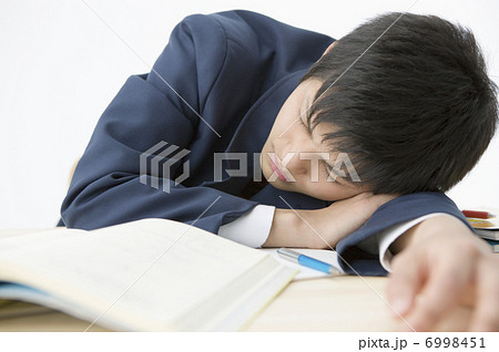 机で寝る男子高校生の写真素材
