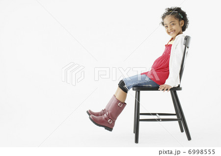 イスに腰掛ける女の子の写真素材