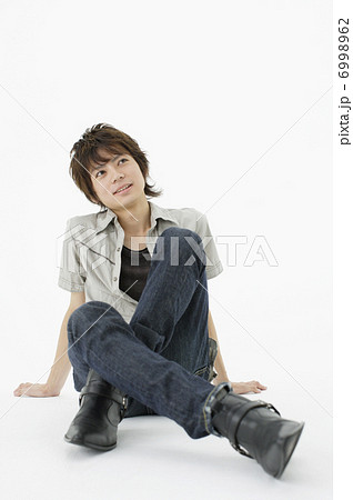 床に座る若い男性の写真素材