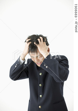 頭を抱え込む男子高校生の写真素材
