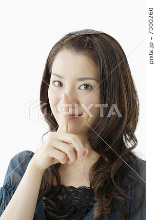 唇に指をあてる若い女性の写真素材