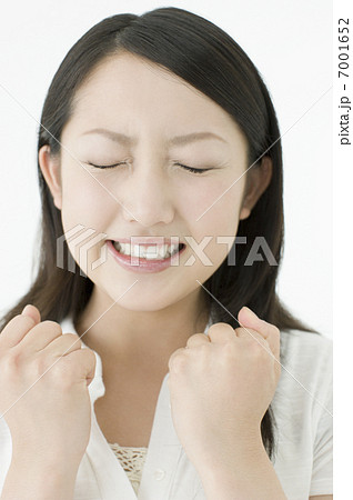 両手を握りしめる若い女性の写真素材