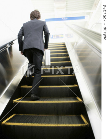 エスカレーターを駆け上がるビジネスマン 7002143